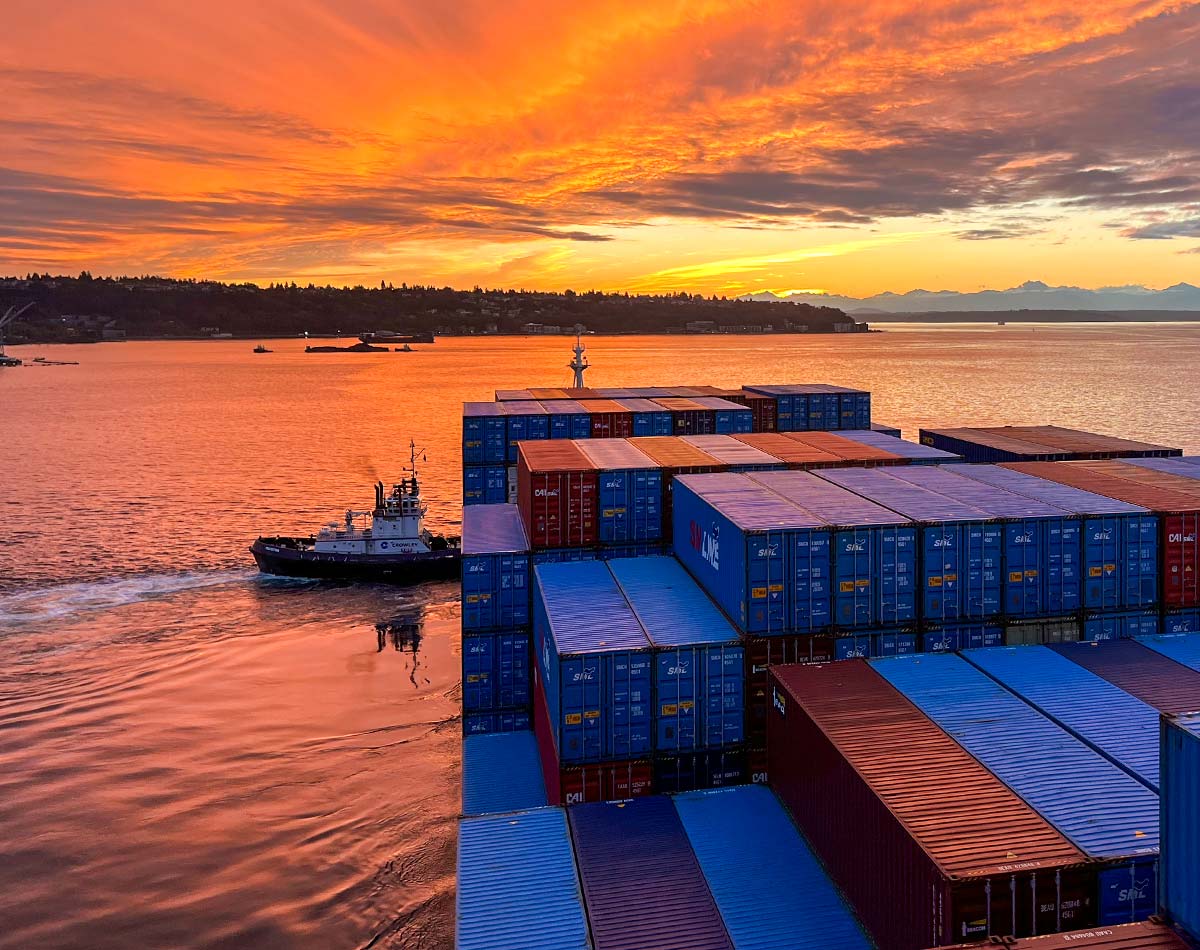 Experts in navigation Stewards of safety photo of a tug pushing a cargo ship